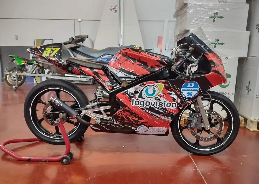 Moto de competición con rotulación Logovisión rojo y negro